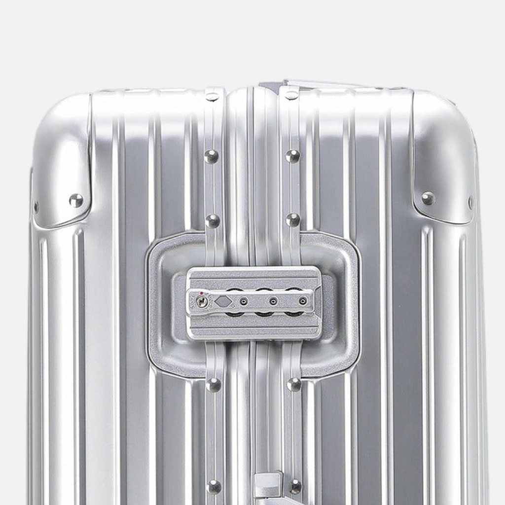 Gros plan sur la serrure TSA d'une valise MoovNext AURA en aluminium et magnésium argenté avec finition rainurée